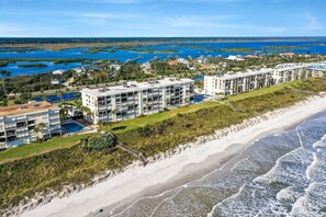 A beachfront hotel with multiple buildings, a swimming pool, and a beach. - Oceanfront Luxury Condo | Renovated | Private Beach Access | Pools | Tennis Court (St. Augustine)