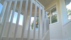 A staircase with a white railing, a ceiling fan, and a window with a view of trees. - Hunter's dream with 640 acres of hunting land (Brocket)