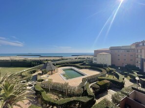 Ein Resort mit Swimmingpool, Meerblick und einem gepflegten Garten.