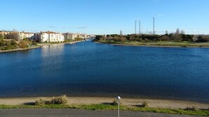Ein Fluss mit Gebäuden und Bäumen im Hintergrund.