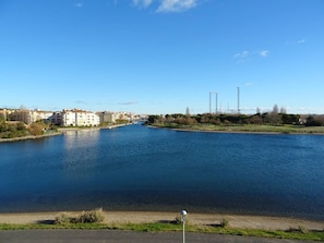 Ein Fluss mit Gebäuden und Bäumen im Hintergrund.