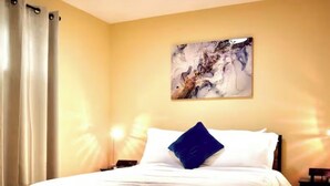 Ein Hotelzimmer mit einem Bett, einem Bild an der Wand und zwei Nachttischlampen.