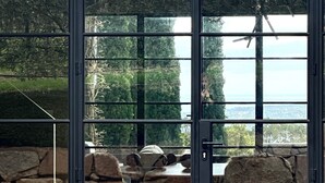 Ein modernes Gebäude mit großen Glasfenstern, einem steinernen Weg und Blick auf einen See.