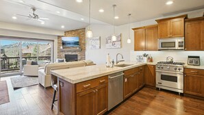 A modern kitchen with wooden cabinets, stainless steel appliances, and a large island. - Family Mountain Retreat | Private Hot Tub (Hideout)
