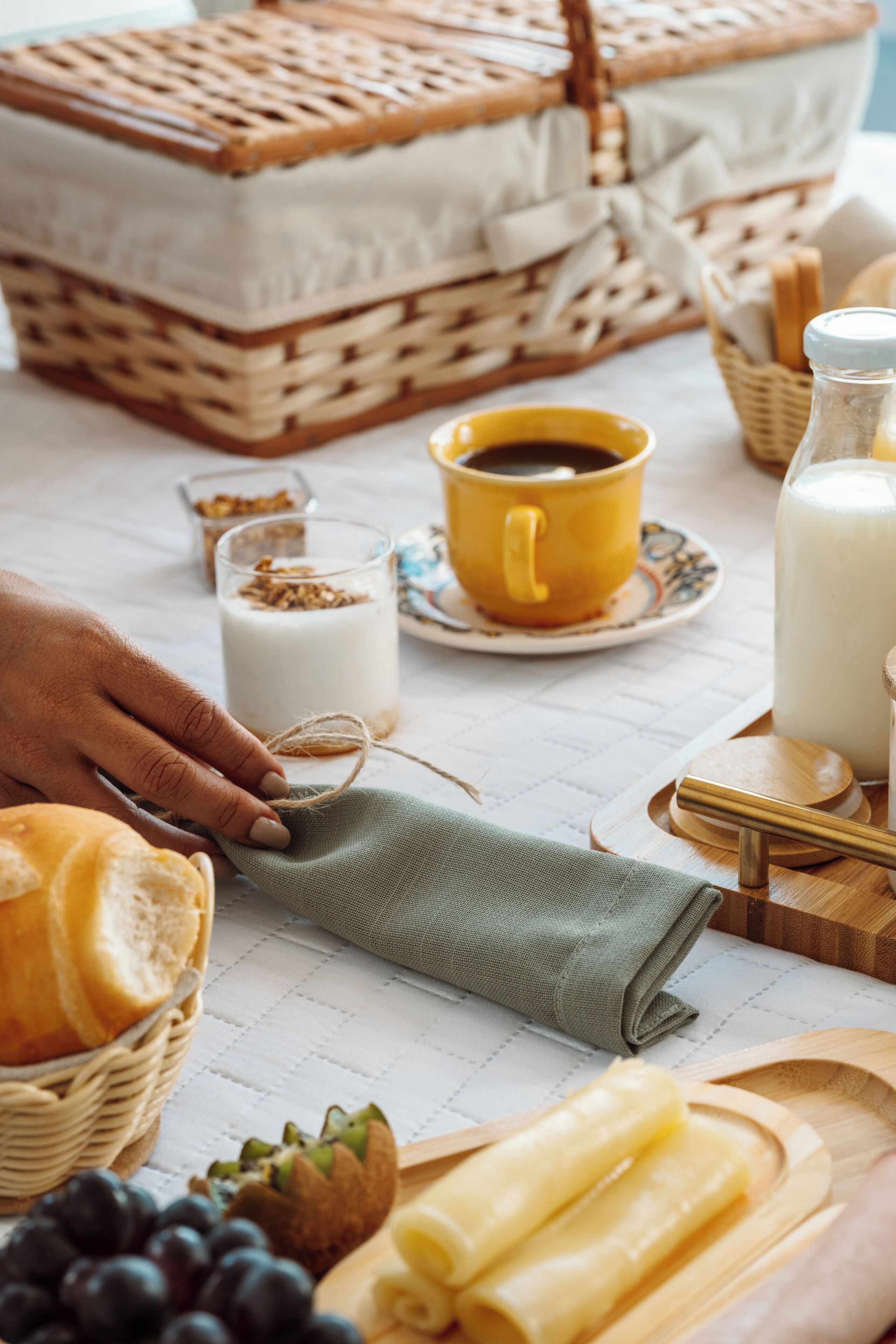 A breakfast setting with bread, fruits, a coffee cup, and a milk bottle.