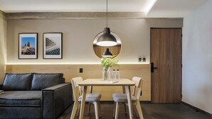 Un salon moderne avec un canapé, une table à manger, des chaises et des œuvres d’art accrochées au mur.