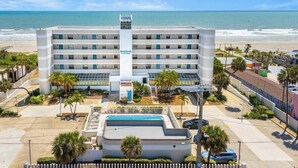 A hotel with a central pool, multiple floors, and a beach view. - Gorgeous Oceanfront Condo With Double Wide Balcony & Complex Pool 🏝️🍹 (Cocoa Beach)