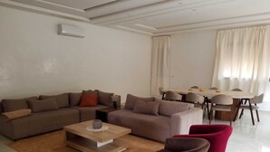 Uma sala de estar moderna com um sofá modular, uma mesa de centro e duas poltronas.