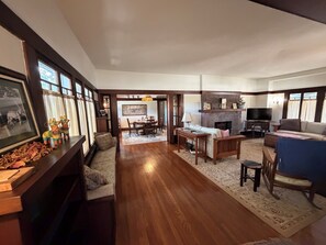 A spacious living room with hardwood flooring, a fireplace, a television, and a dining area with a table and chairs. - Historic Craftsman Bungalow Old Pasadena Rose Bowl 3 miles, LA Coliseum (Pasadena)