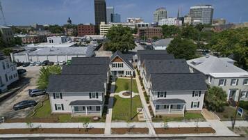 A residential area with houses, a parking lot, and a city skyline in the background.
