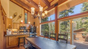 A spacious kitchen with wooden cabinets, a large island, and a dining area with a table and chairs. - Monthly Lease - Pine Trail at Alpine Meadows - Pet Friendly w Hot Tub at Alpine Meadows (Alpine Meadows)