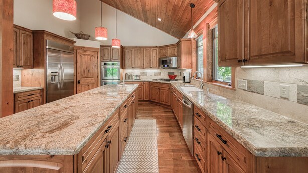 A kitchen with wooden cabinets, granite countertops, stainless steel appliances, and pendant lighting. - Monthly Lease - Freedom Lodge by Tahoe Getaways - 4BR Centrally Located w/ Bonus Room (Truckee)