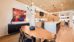 Een moderne keuken met houten kastjes, een centraal eiland en hanglampen.