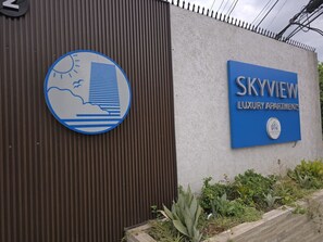 A sign for Skyview Luxury Apartments with a weather symbol and a logo. - CTBH @ SkyView Retro Chick and Calming Seas (Kingston)