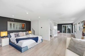 Un dormitorio moderno con una cama, mesitas de noche y un cuadro en la pared.