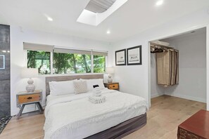A modern bedroom with a large bed, bedside tables, a wardrobe, and a skylight. - Hollywood Hills Vista | Decks & Fire Pit by C&C (Los Angeles)