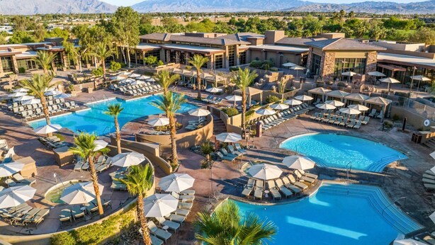 Ein Resort mit mehreren Schwimmbecken, Liegestühlen und Sonnenschirmen.