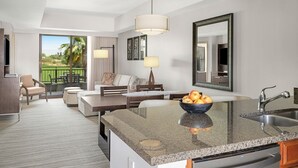Ein modernes Hotelzimmer mit Kücheninsel, Essbereich und einem Balkon mit Aussicht.