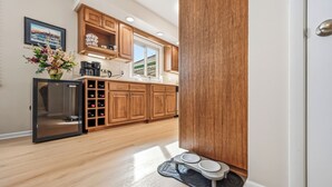 A kitchen with wooden cabinets, a refrigerator, a sink, and a window. - Cozy fully remodeled home in Hermitage. (Hermitage)