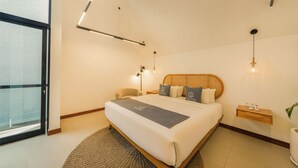 A modern hotel room with a large bed, bedside tables, a small desk, and a view through a glass door. - Luxury 2 Bedroom Villa with Private Pool in Umalas (Badung)