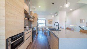 Eine moderne Küche mit Holzschränken, Edelstahlgeräten und einer zentralen Kochinsel.