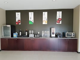 Una kitchenette equipada con refrigerador, cafetera, tostadora y microondas.