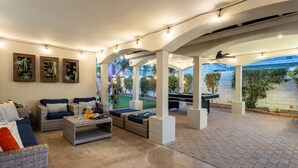 An outdoor patio with wicker furniture, a ping pong table, and wall-mounted planters. - Swim-In Theater Oasis w/ Gated Pool Sleeps 12 (Indio)