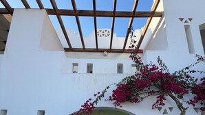 A white building with a wooden pergola, a glass door entrance, and outdoor seating. - MDS Coral Bay Pearl | Sea View | Resort (South Sinai Governorate)