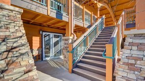 A multi-level building with a staircase, stone walls, and a balcony. - Adventure Trails - Golf View + Hot tub | Waterpark (Wisconsin Dells)