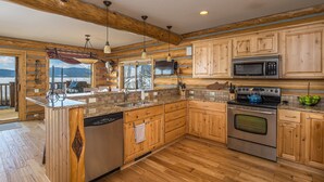 A kitchen with wooden cabinets, a stainless steel stove, and a dishwasher. - Lake house 16 minutes from Yellowstone (West Yellowstone)