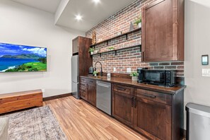 A modern kitchen with wooden cabinets, a brick backsplash, and a stainless steel dishwasher.