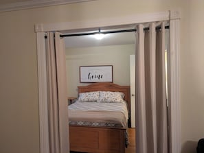 A bedroom with a bed, a bedside table, and a wall-mounted picture frame with text. - Serenity in the Pines: Farmhouse with 3bd, 2bth and a rap-around porch! (Manchester)