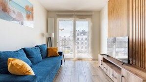 Un salon moderne avec un canapé bleu, un meuble en bois et un tableau accroché au mur.