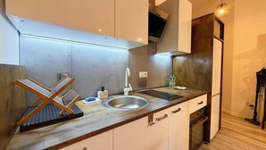 Eine moderne Küche mit Spüle aus Edelstahl, einer Holz Arbeitsplatte und einem eingebauten Backofen.
