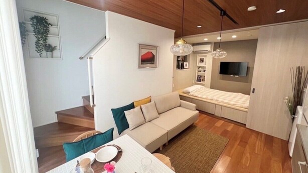 Una sala de estar moderna con un sofá, una mesa de comedor y un televisor.