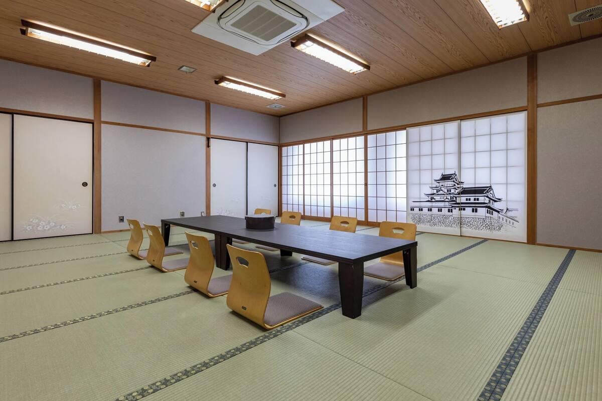 A traditional Japanese room with tatami flooring, a low table, and sliding doors.