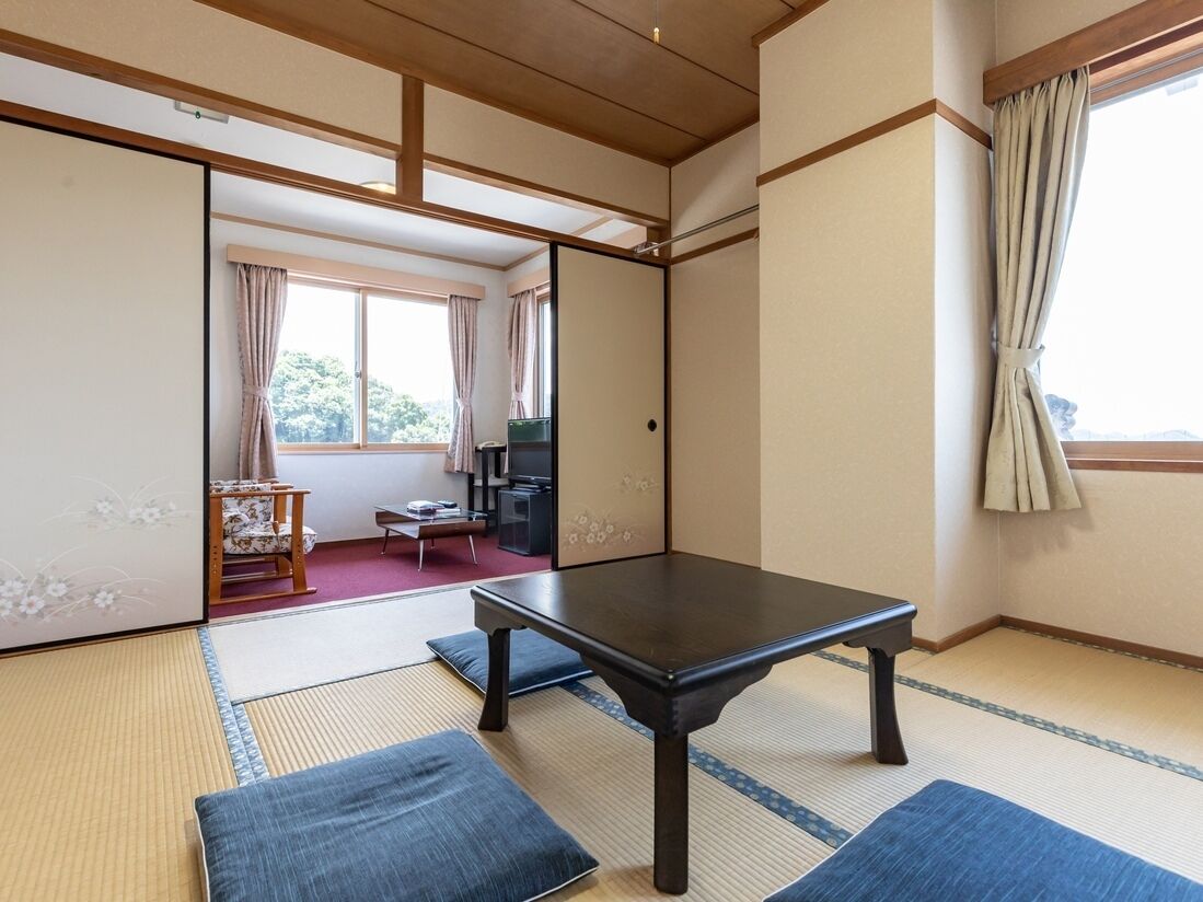 A traditional Japanese room with tatami flooring, a low table, and sliding doors.