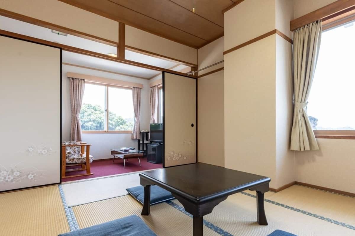 A traditional Japanese room with tatami flooring, a low table, and sliding doors.