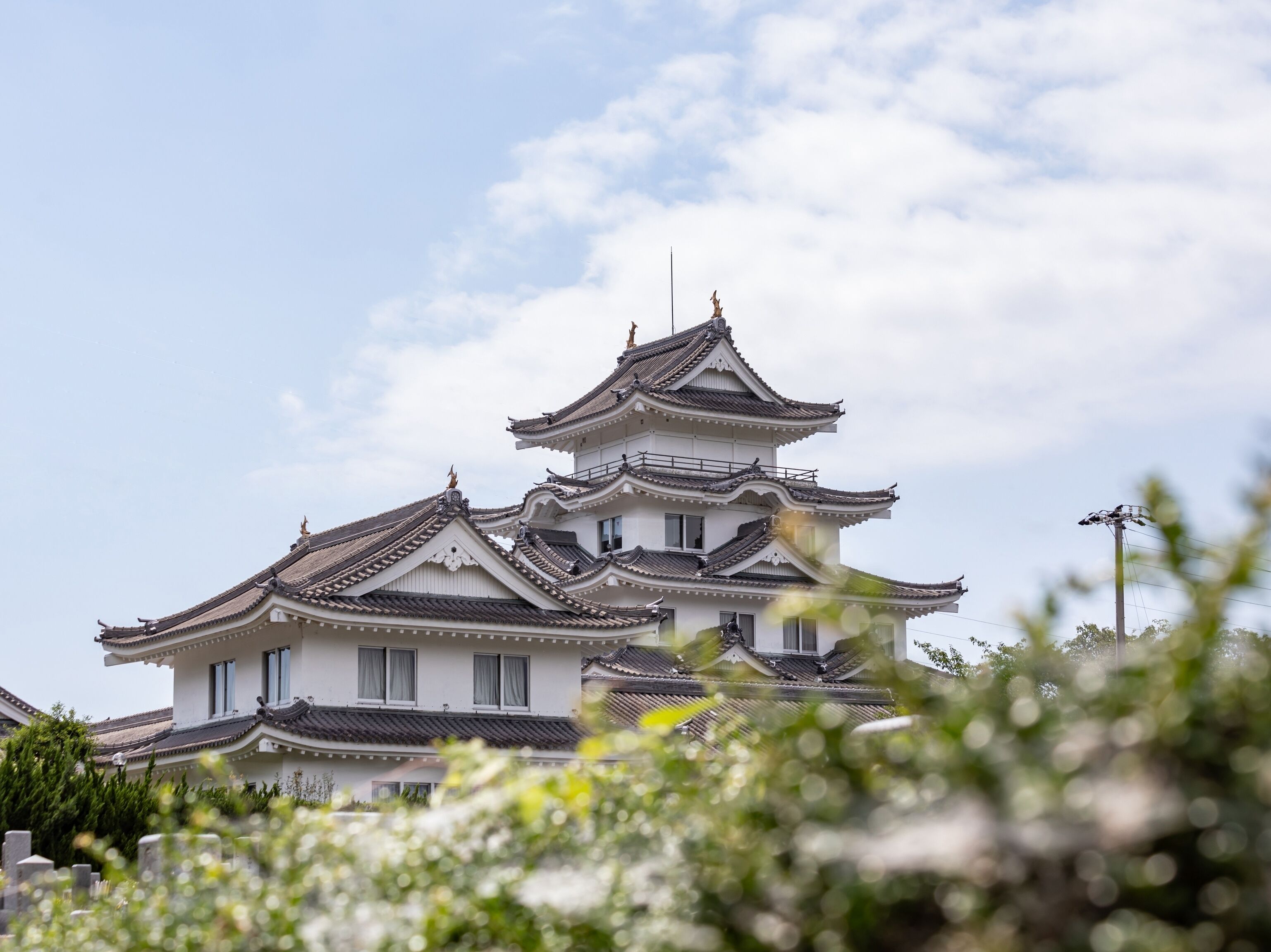 A traditional multi-tiered building with a symmetrical roofline and a prominent central tower.
