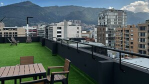 A rooftop terrace with artificial grass, outdoor seating, and a cityscape view. - Modern Studio in Chicó Norte (Bogotá, D.C.)