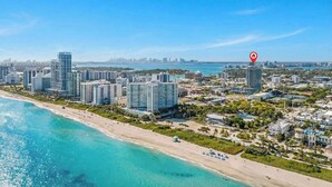 Un paisaje urbano costero con rascacielos, una playa y un cielo azul despejado.