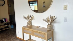Ein Badezimmer mit rundem Spiegel, Holzschrank und zwei dekorativen Vasen.