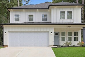 A two-story house with a garage, a front door, and a mailbox. - Luxurious New Construction 4-bedroom house in charming Decatur (Decatur)