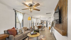 Un salon moderne avec un canapé, une table basse et un ventilateur de plafond.