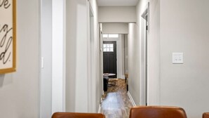 A hallway leading to a dining area with a table and chairs. - Church Hill Hideaway #1 | 3 BR Backyard Oasis (Richmond)
