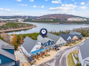 Un quartier résidentiel avec des maisons, un lac et un panneau indiquant un lieu.
