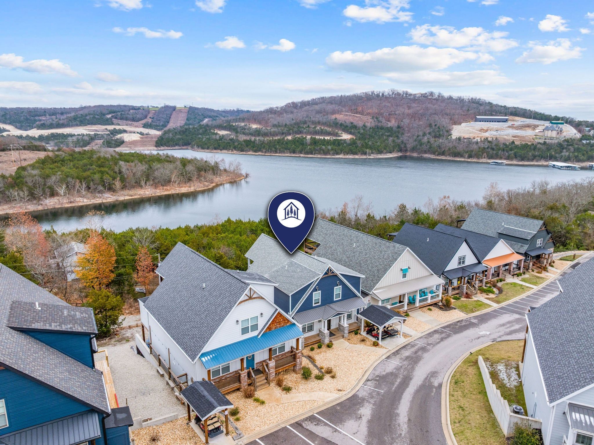 Un quartier résidentiel avec des maisons, un lac et un panneau indiquant un lieu.