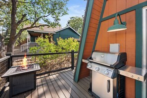 An outdoor barbecue area with a grill and a fire pit on a wooden deck. - Starlight Lodge - Family-Friendly Gambrel Cabin | 5 Min to Slopes, Lake & Dining (Big Bear City)
