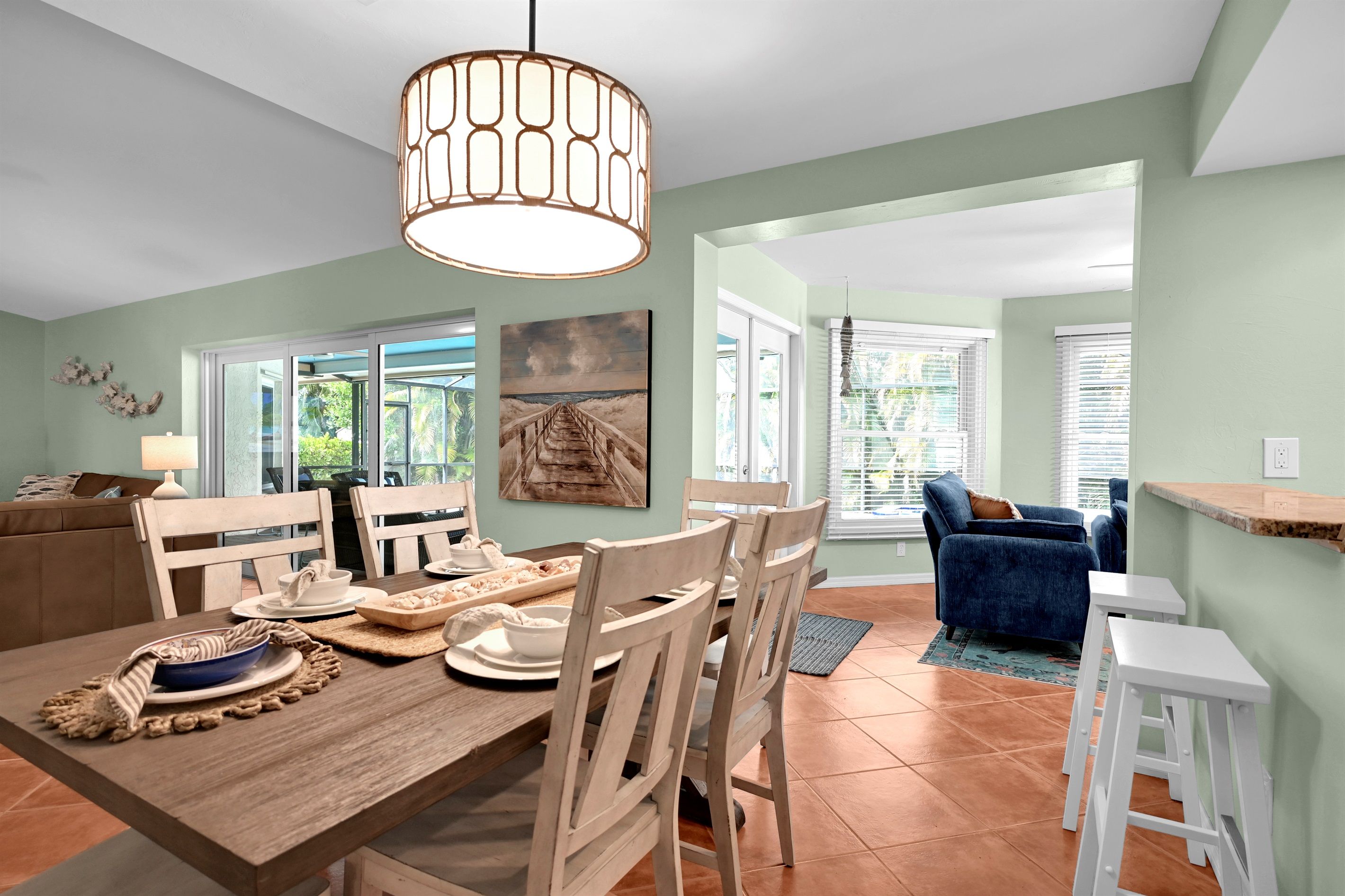 A dining area with a wooden table, chairs, and a hanging light fixture.