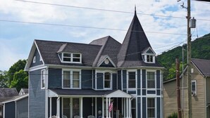 A two-story house with a steeply pitched roof, a front porch, and a small front yard. - Traditional Bed & Breakfast in Irvine KY with Swimming pool, Wi-Fi Room 2 (Irvine)